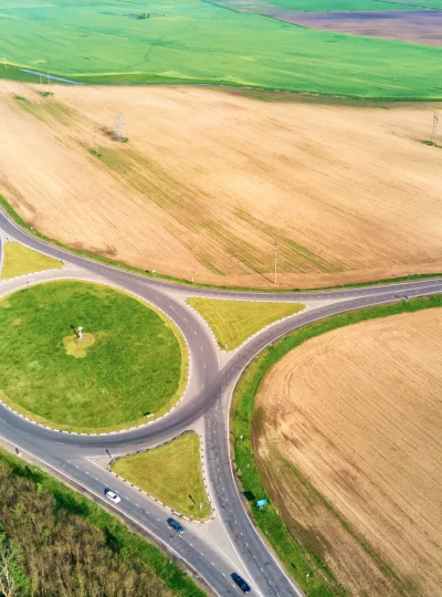 Luftaufnahme eines Kreisverkehrs inmitten von Feldern